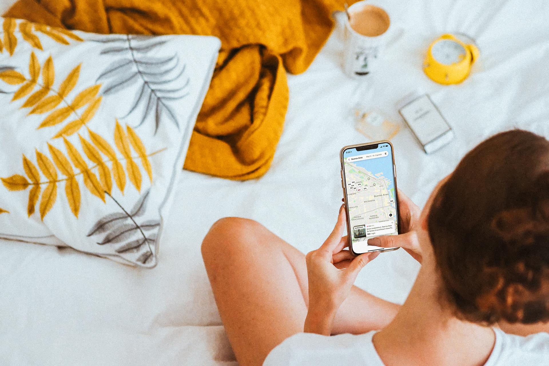 a woman looks at the Airbnb app on her cell phone