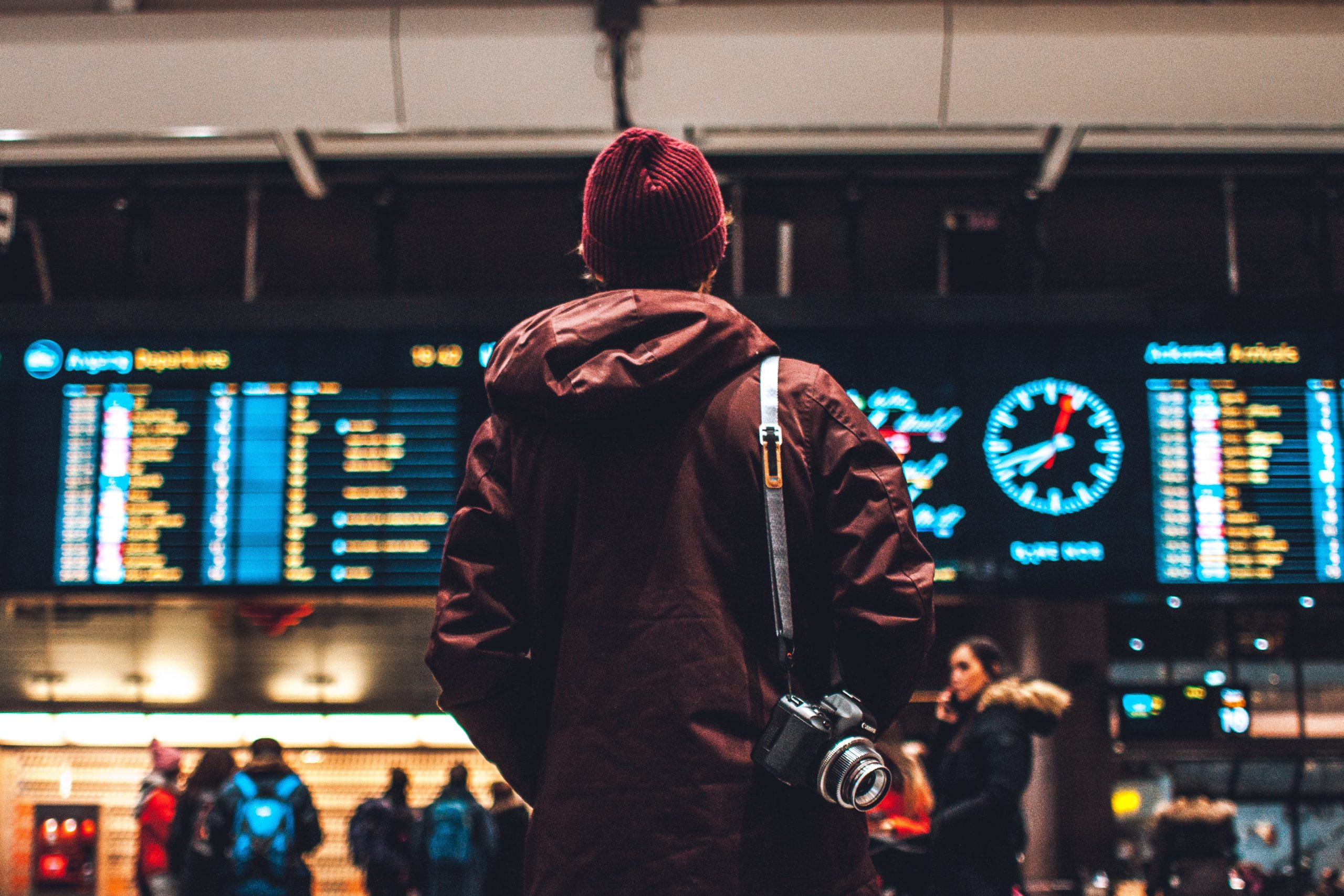 a person stands in the airport looking at the flight board