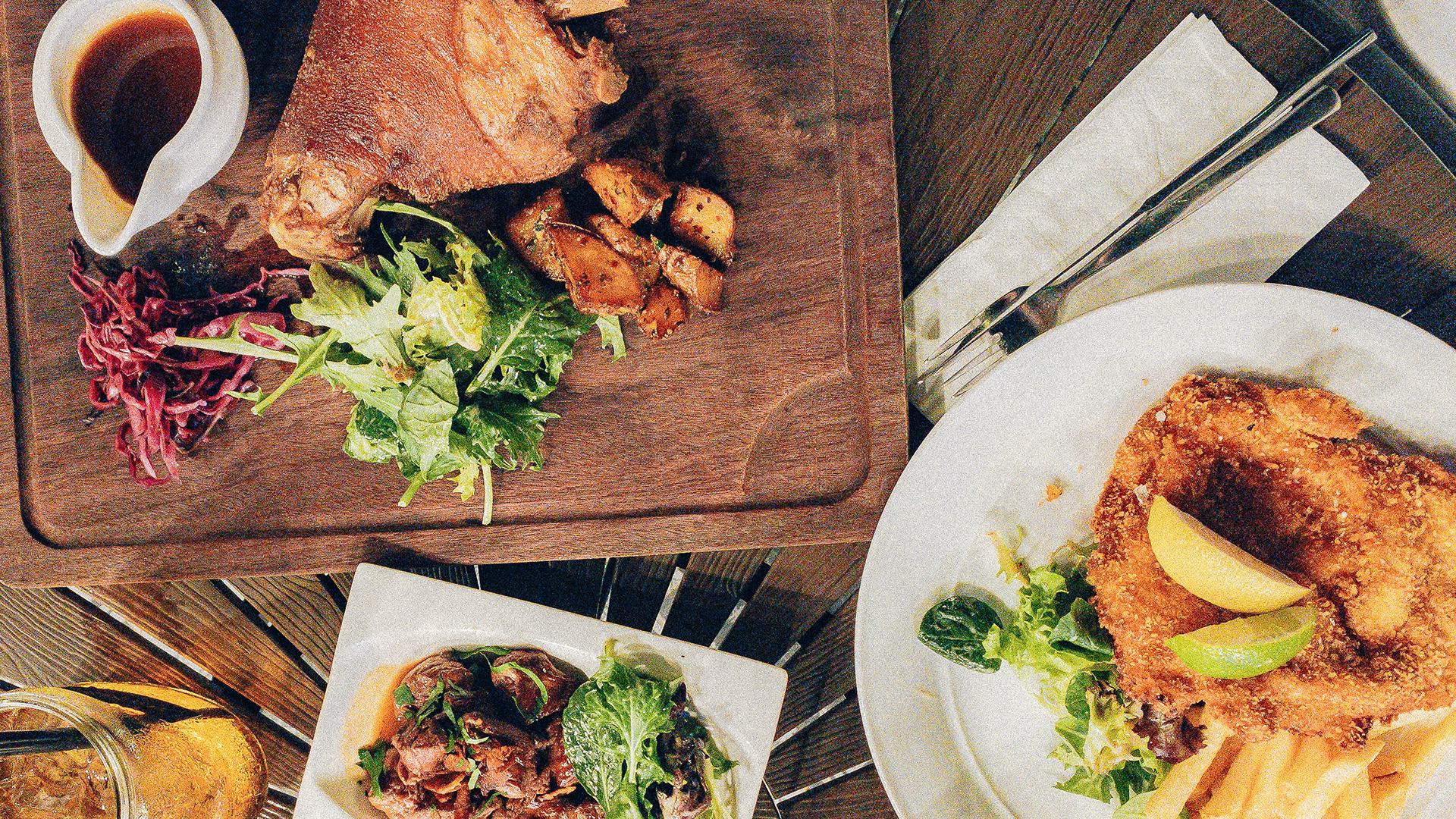 plates of German food, including schweineshaxe and wienerschnitzel with French fries